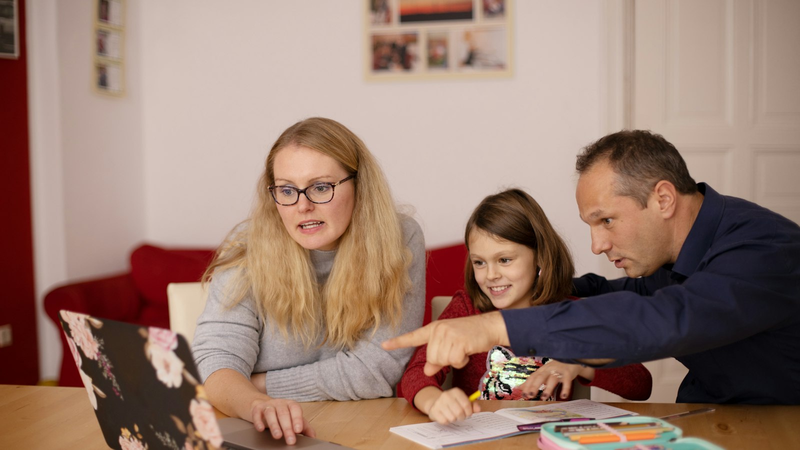 Mutter und Tochter sehen sich zu Hause gemeinsam die Hausaufgaben an