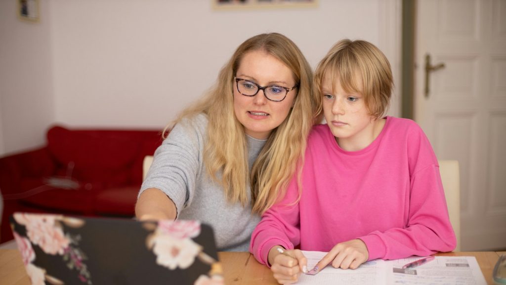 Madre e hija revisando juntas las tareas escolares en casa