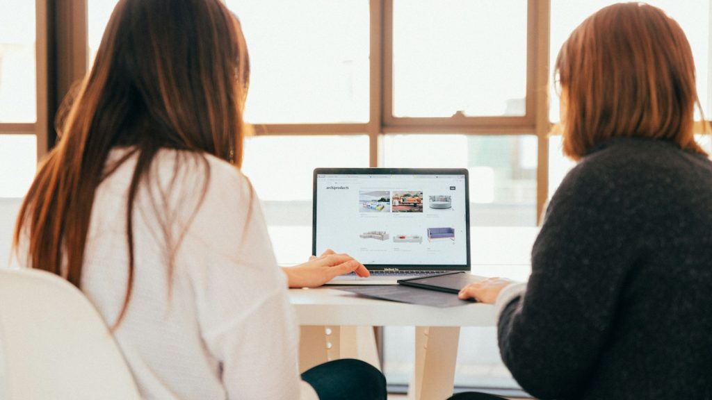 Dos compañeras revisando contenidos de formación en un portátil