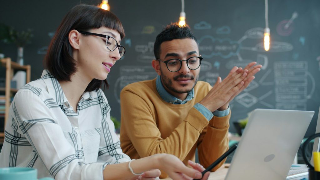 Dos compañeros revisando el progreso de la formación en un portátil